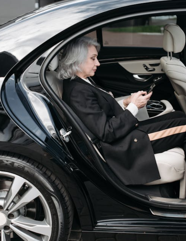 Elegant woman using phone in a car.