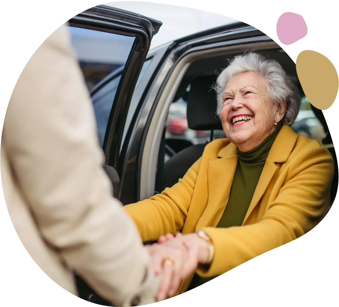 Happy senior woman getting help into car.